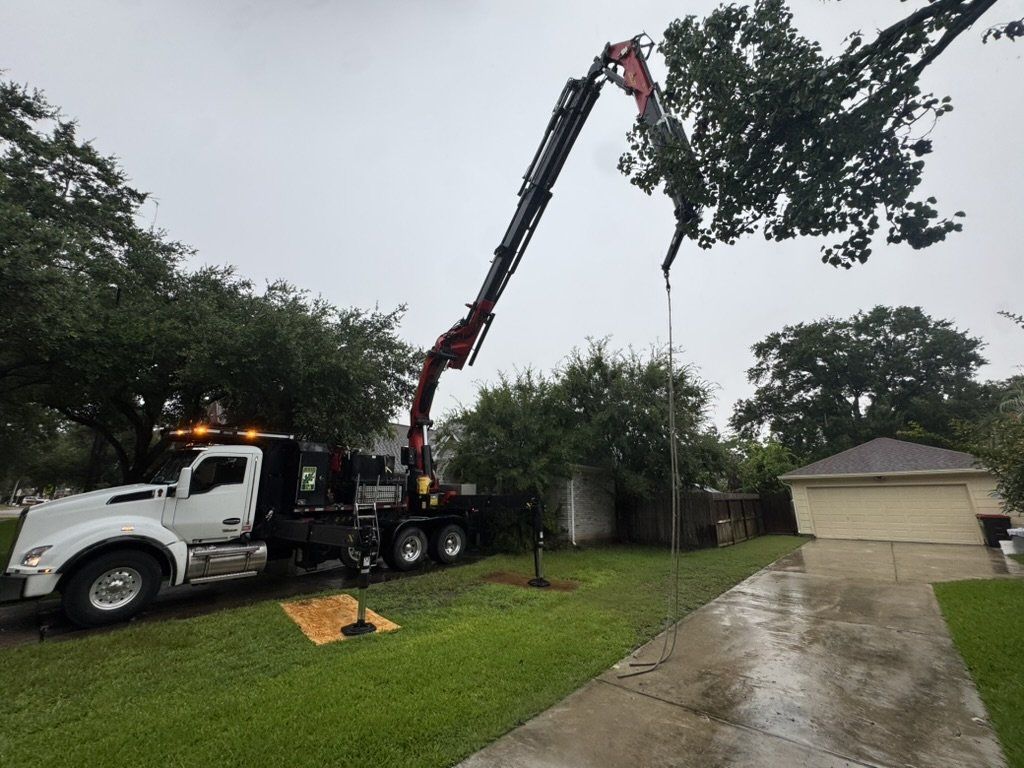 Grapple crane reaching over a house in the rain